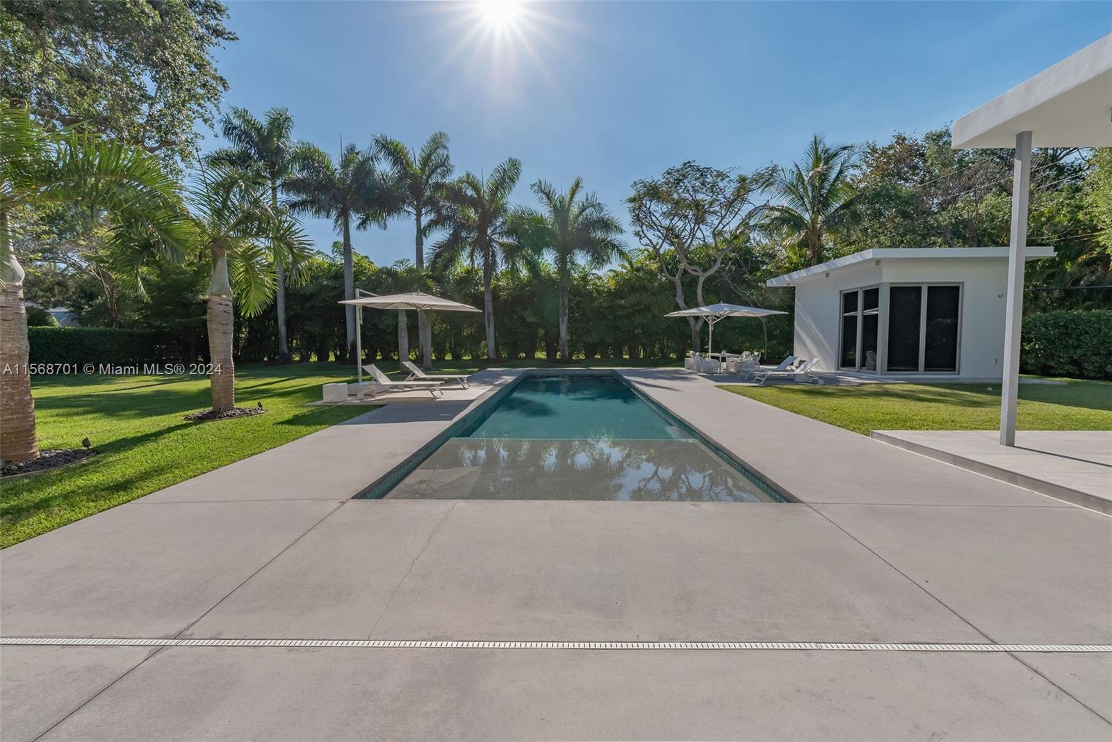 6795 Southwest 113th Street Pinecrest, FL 33156 - Photo 22 of 30 a view of a swimming pool with palm trees