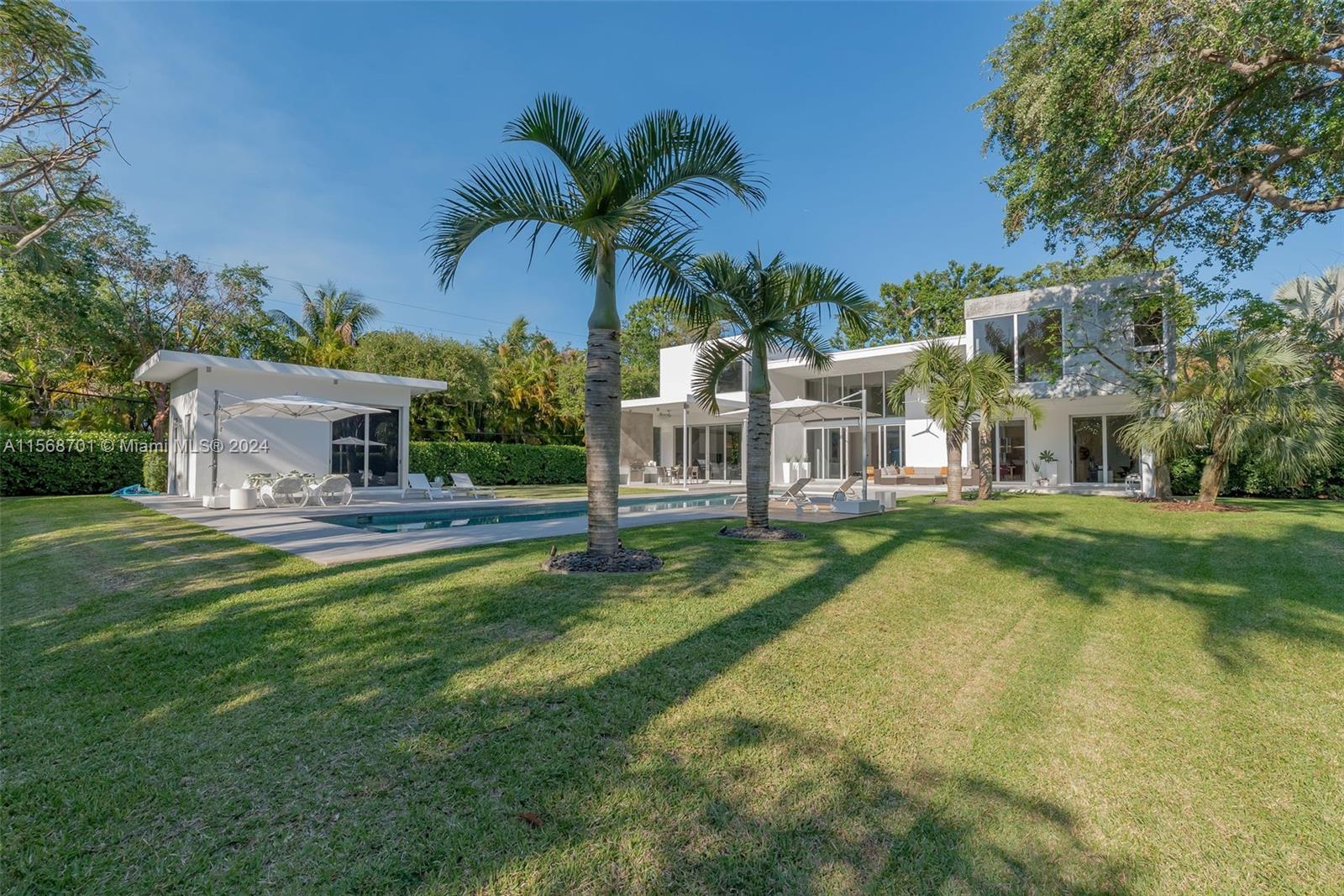 6795 Southwest 113th Street Pinecrest, FL 33156 - Photo 25 of 30 a front view of a house with swimming pool having outdoor seating