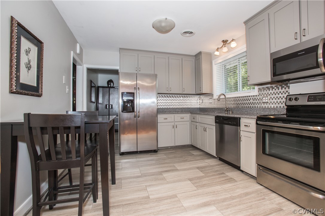 1620 Featherstone Drive Midlothian, VA 23113 - Photo 14 of 29 a kitchen with stainless steel appliances granite countertop a stove top oven a sink dishwasher and white cabinets