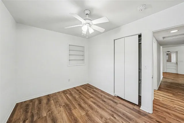 a view of a livingroom with wooden floor and a ceiling fan