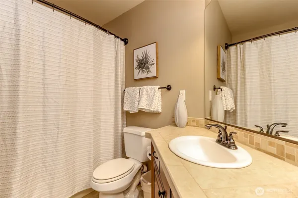 a bathroom with a sink a toilet and a mirror