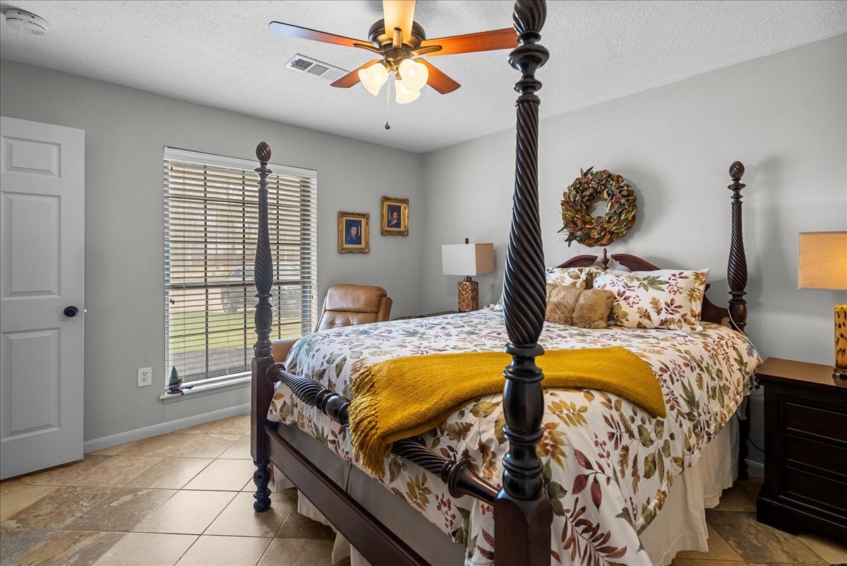 7111 Tonkawa Street Baytown, TX 77521 - Photo 13 of 23 a bedroom with a bed and a chandelier