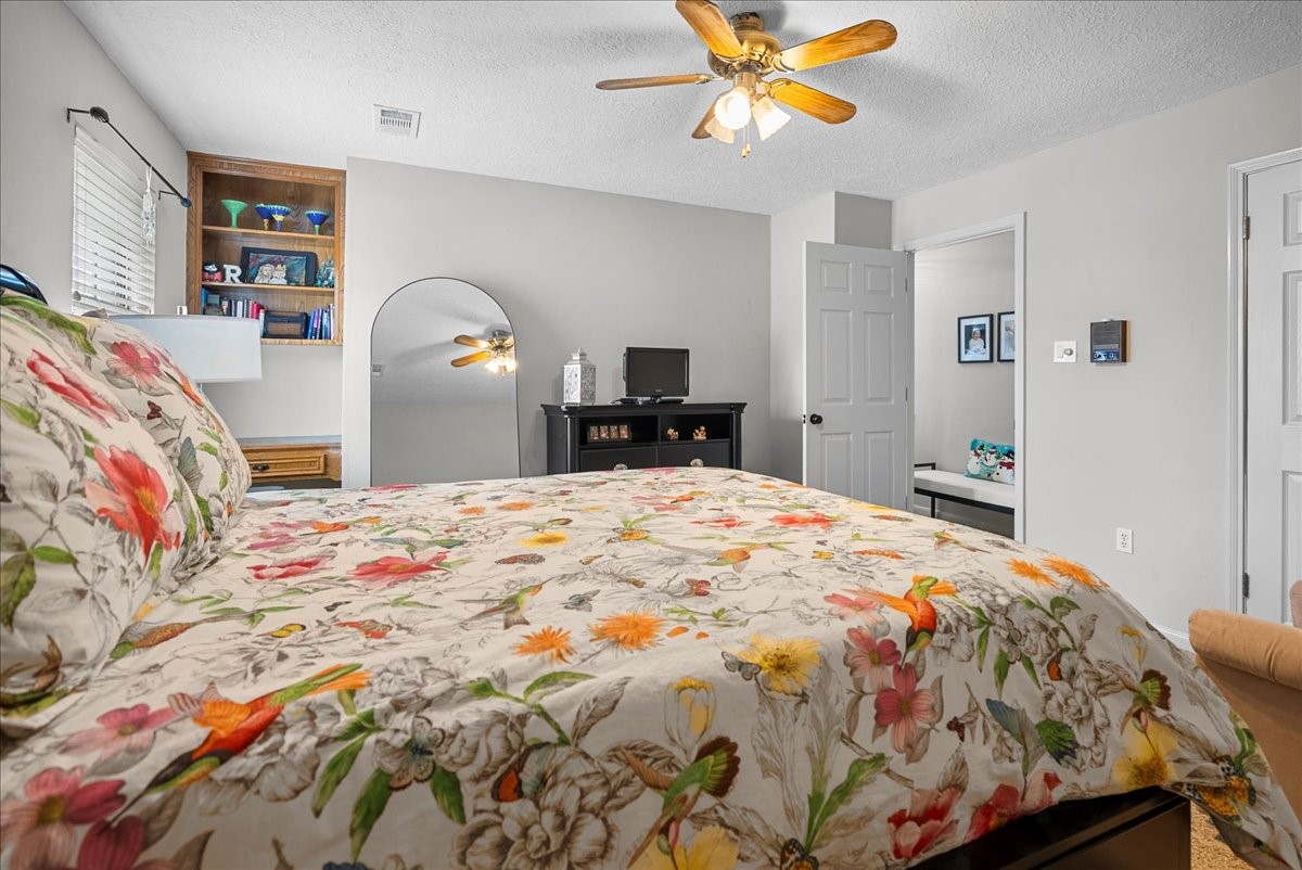 7111 Tonkawa Street Baytown, TX 77521 - Photo 20 of 23 a bedroom with a bed and a chandelier