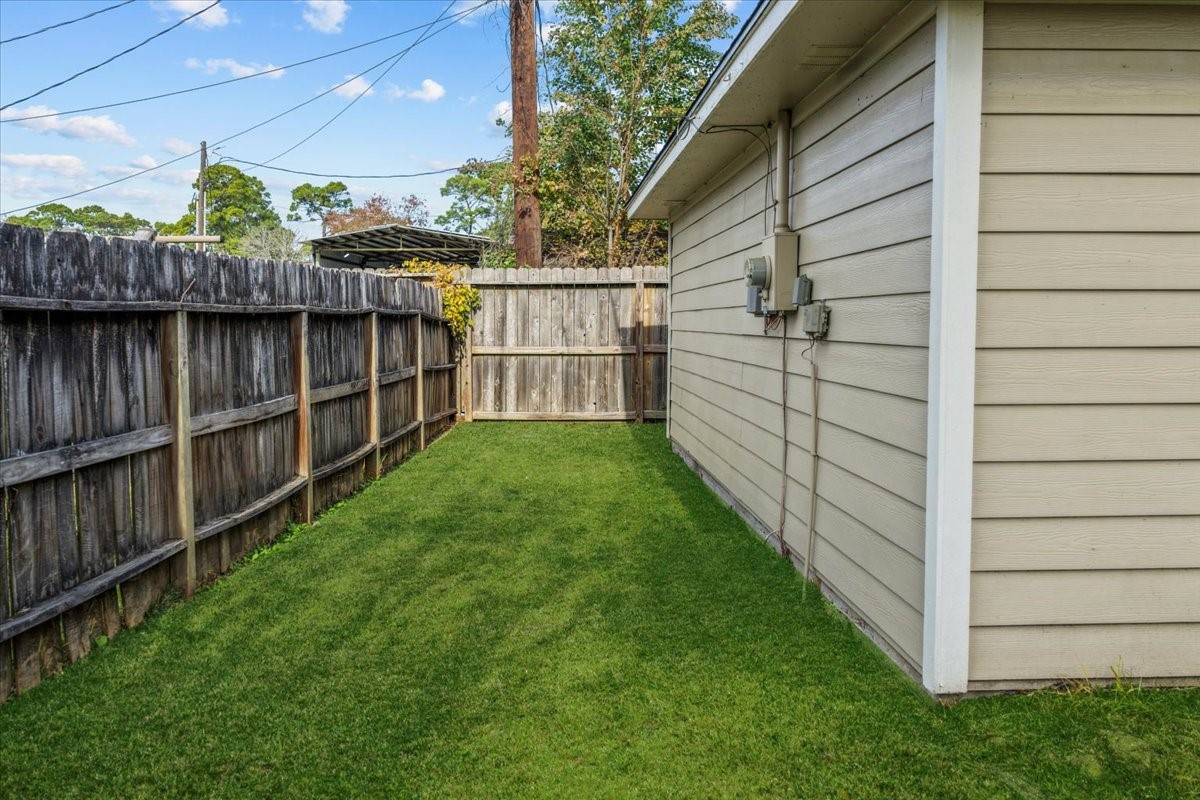 7111 Tonkawa Street Baytown, TX 77521 - Photo 22 of 23 a view of a backyard with a large tree and wooden fence
