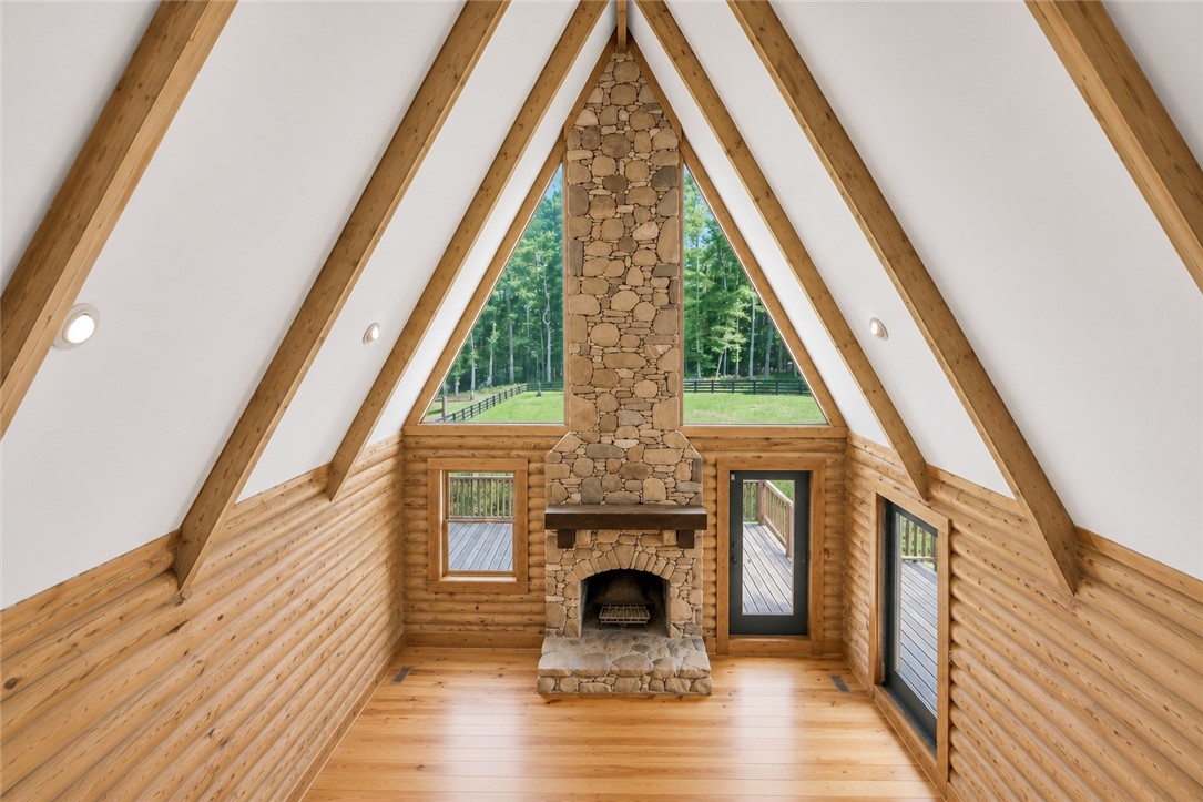 414 Devon Way Anderson, SC 29621 - Photo 21 of 50 A-frame design with log walls and hardwood floors, centered around a grand stone fireplace with natural light.
