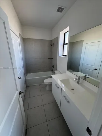 an empty room with windows and ceiling fan