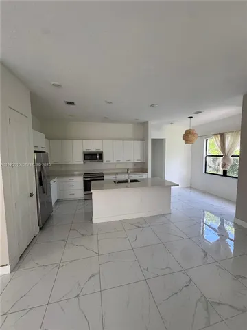 a large kitchen with cabinets and stainless steel appliances