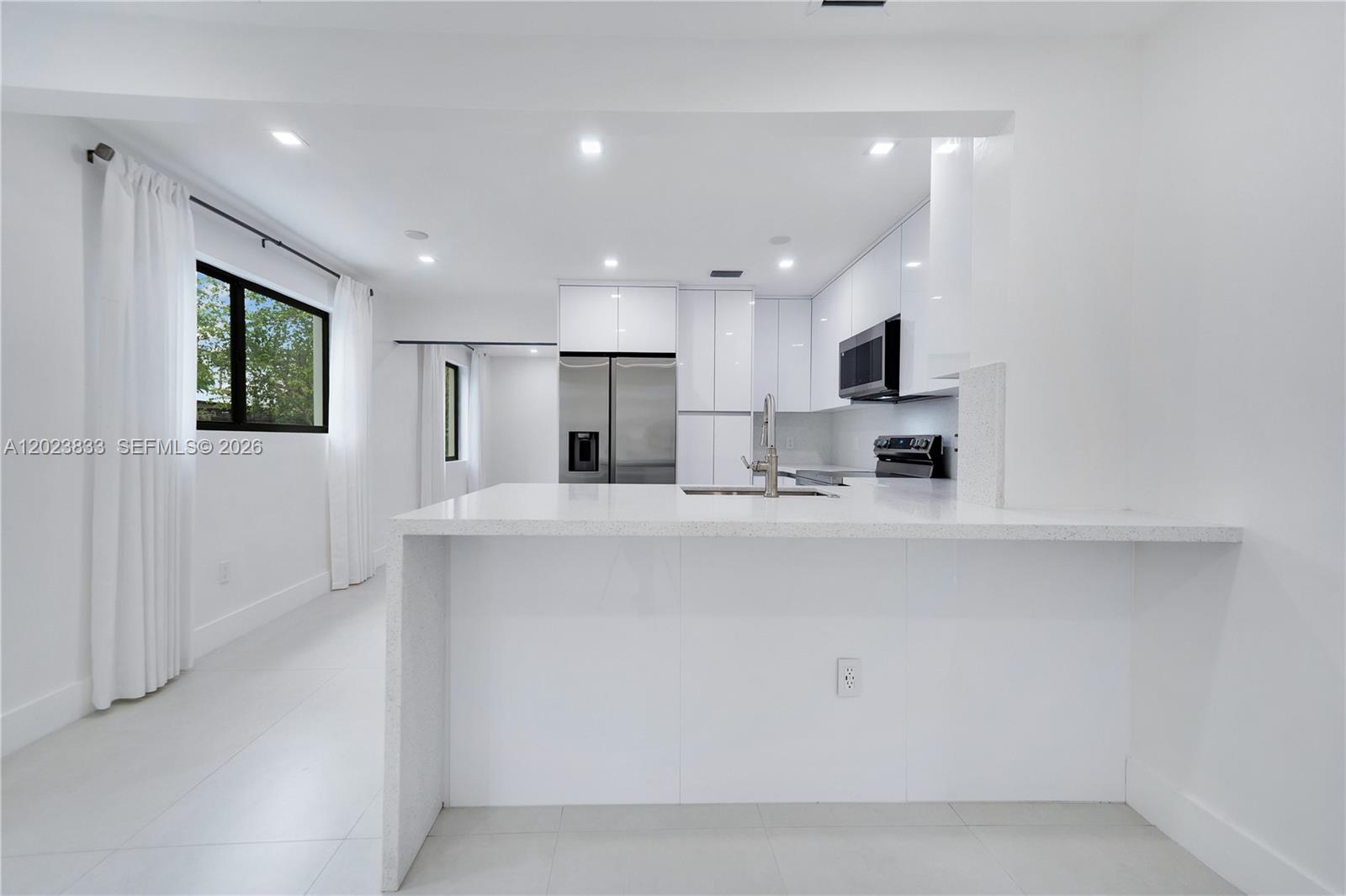 6566 Southwest 35th Street Miami, FL 33155 - Photo 10 of 36 a open kitchen with white cabinets and stainless steel appliances