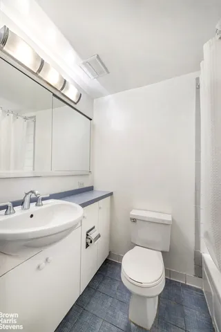 a bathroom with a toilet sink and mirror