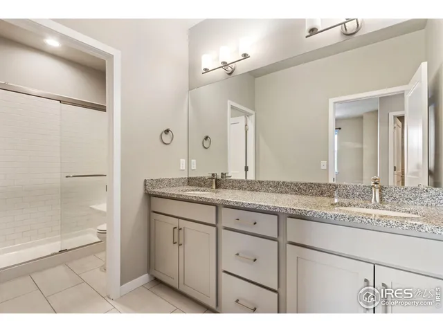 a bathroom with a granite countertop sink a mirror and a shower