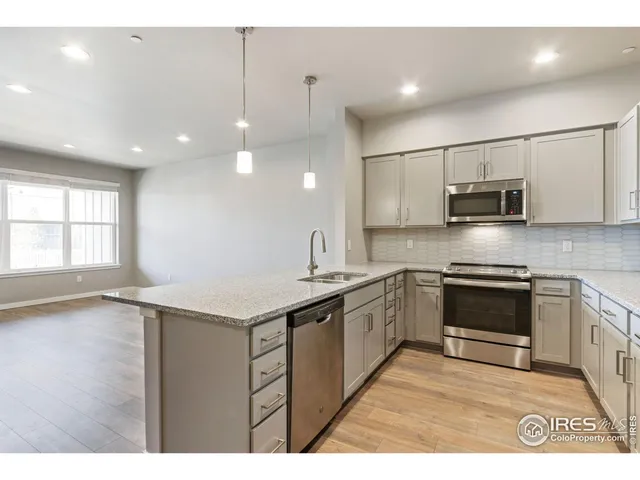 a kitchen with kitchen island a sink stainless steel appliances and cabinets