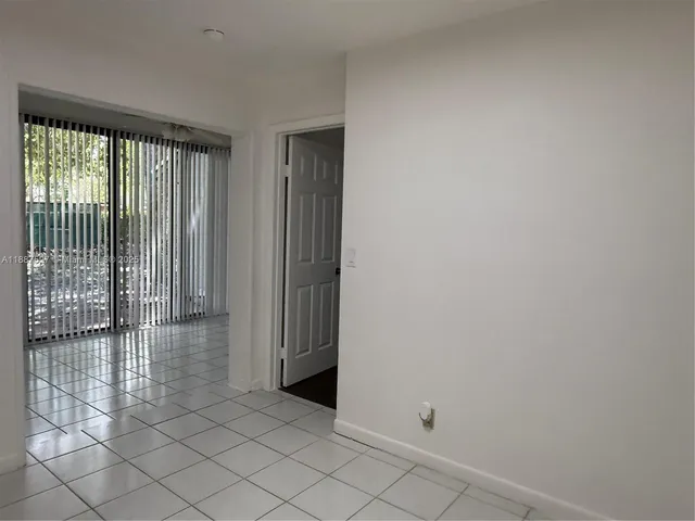 a view of a hallway with wooden floor and a bathroom
