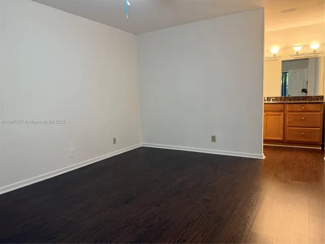 a view of a room with wooden floor and cabinets