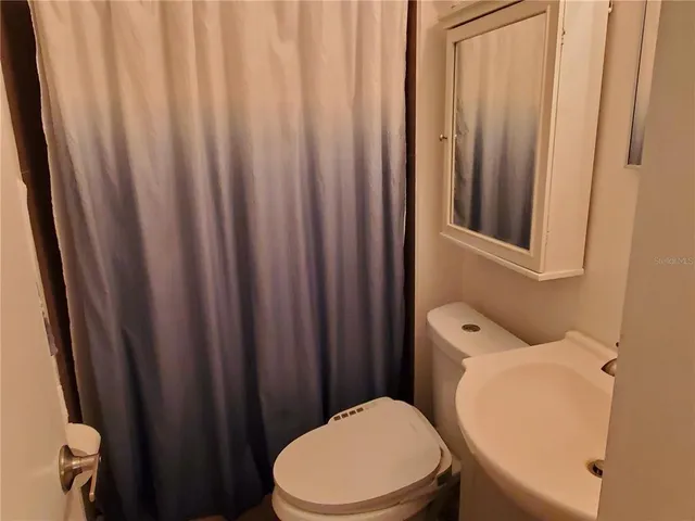 a white toilet sitting next to a shower curtain