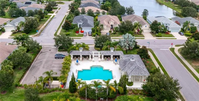 an aerial view of residential houses with outdoor space and trees