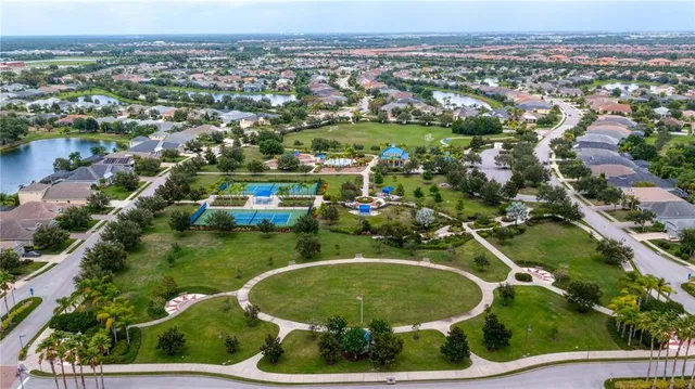 an aerial view of residential houses with outdoor space and parking