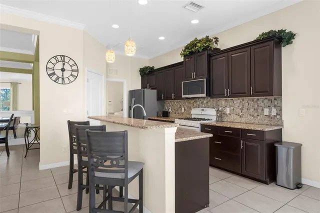 a kitchen with granite countertop a sink a stove and a wooden cabinets