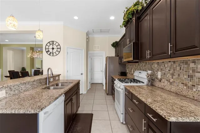 a kitchen with stainless steel appliances granite countertop a sink stove and cabinets