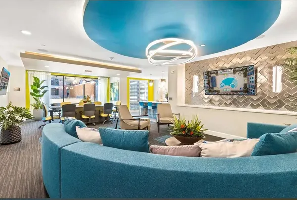 a living room with furniture potted plant and a large window