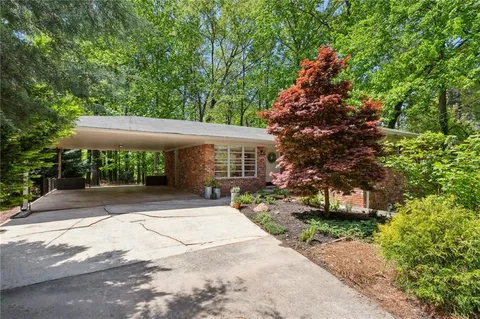 a front view of a house with a yard and potted plants