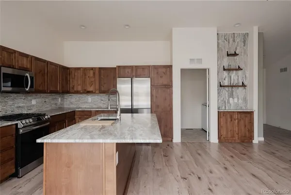a kitchen with granite countertop a sink a stove and cabinets