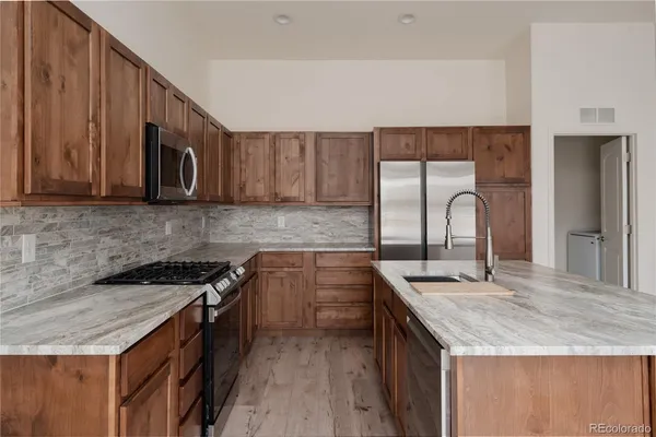 a kitchen with granite countertop a stove and a microwave with sink