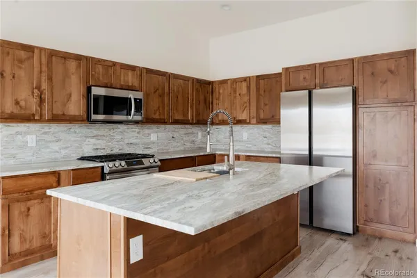 a kitchen with granite countertop a stove and a microwave