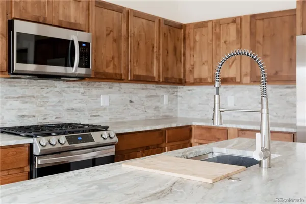 a kitchen with granite countertop cabinets stainless steel appliances and wooden cabinets