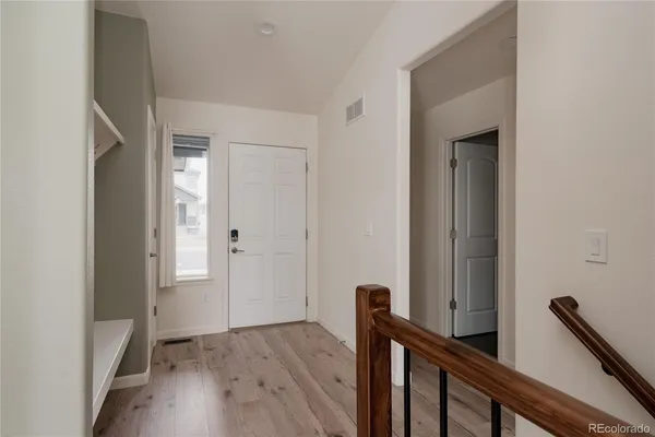 a view of a hallway with entryway and wooden floor