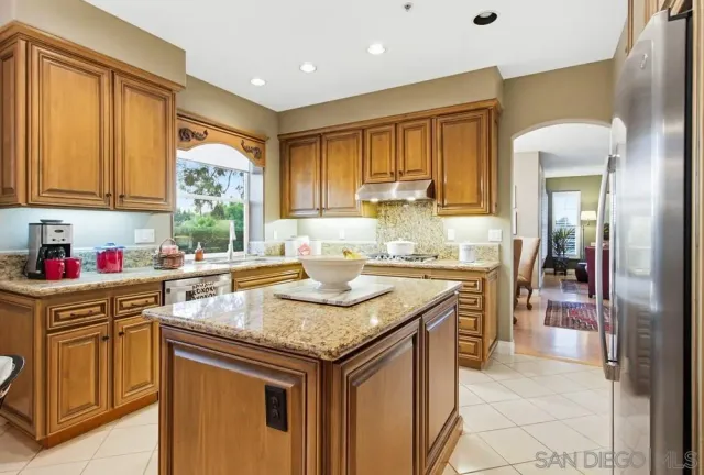 a kitchen with granite countertop a sink stove and cabinets