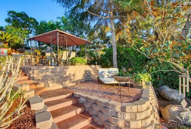 a view of backyard with outdoor seating and trees