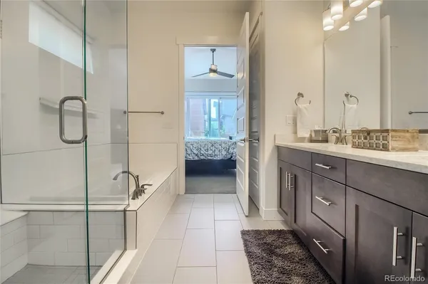 a bathroom with a double vanity sink a toilet and a shower