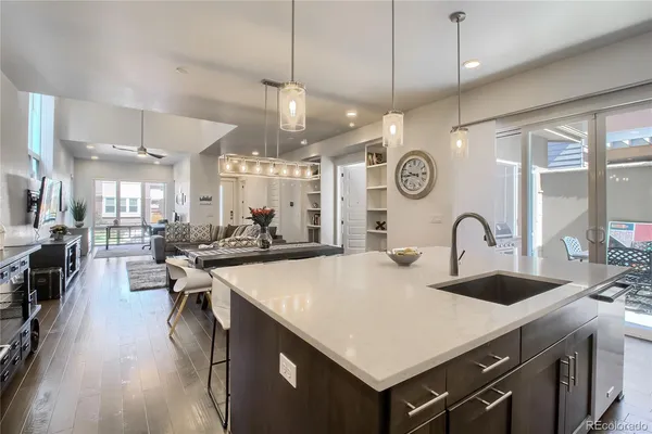 a large kitchen with a counter space a sink appliances and living room view