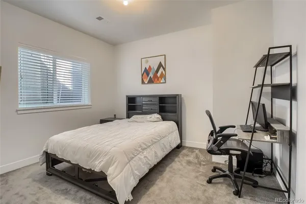 a bedroom with a bed a desk and chair