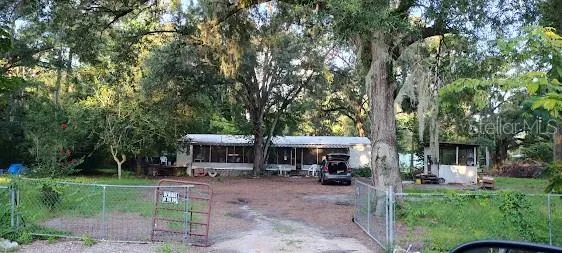 a view of a house with backyard and a tree