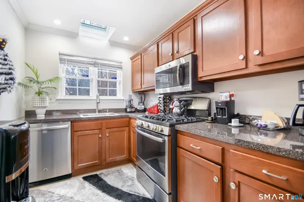a bathroom with a granite countertop sink and a window