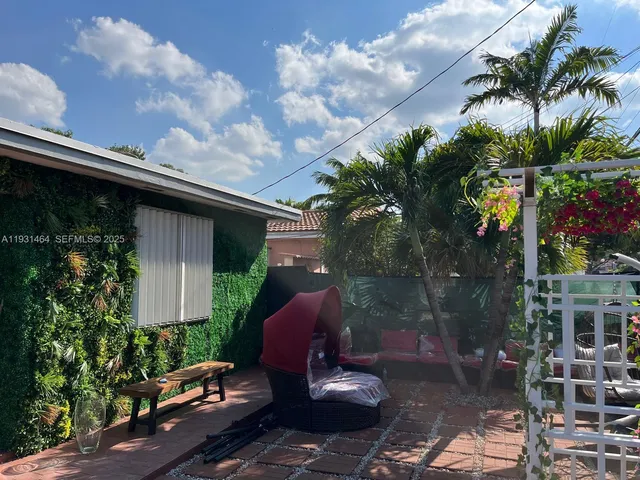 a view of a porch with chairs and potted plants
