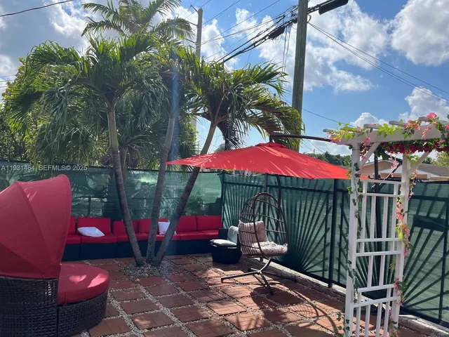 a view of a patio with furniture and a backyard