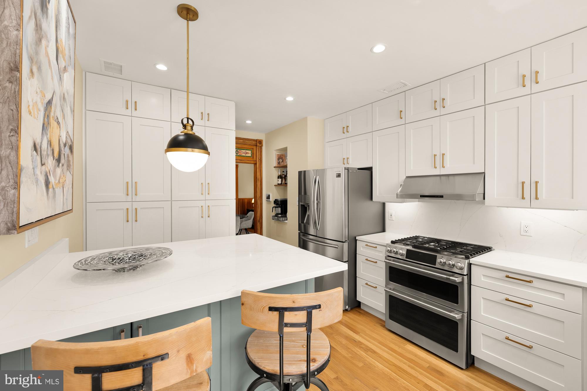 1214 T Street Northwest Washington, DC 20009 - Photo 10 of 88 a kitchen with stainless steel appliances a stove a refrigerator a sink a dining table and chairs with wooden floor