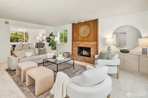 a living room with furniture a fireplace and a potted plant