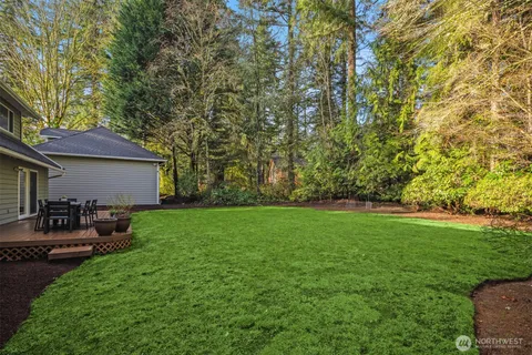 a view of a backyard with couches under an umbrella