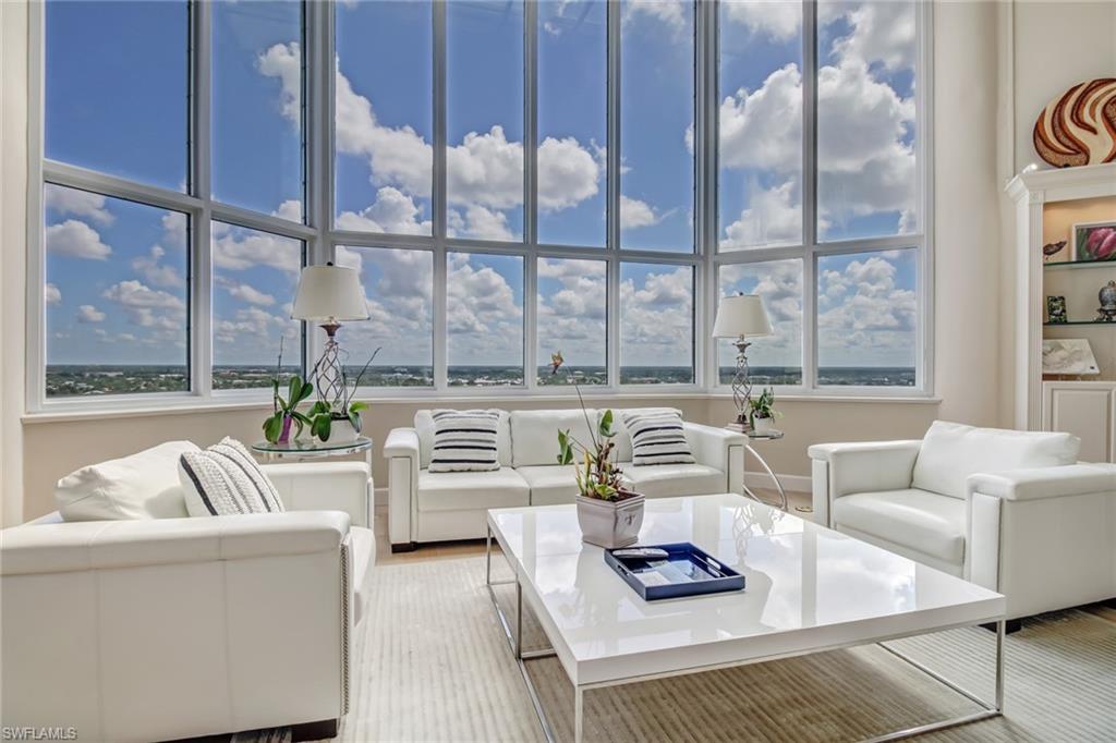 a living room with furniture and a floor to ceiling window