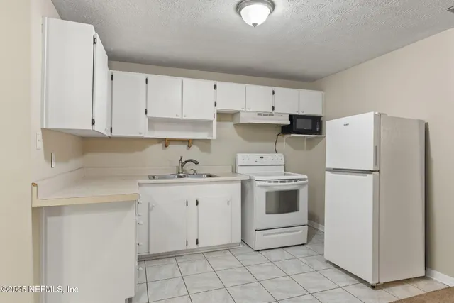 a kitchen with white cabinets and white appliances
