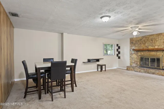 a view of a dining room with furniture and a fireplace
