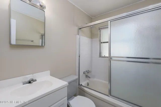 a bathroom with a bathtub shower sink vanity and toilet