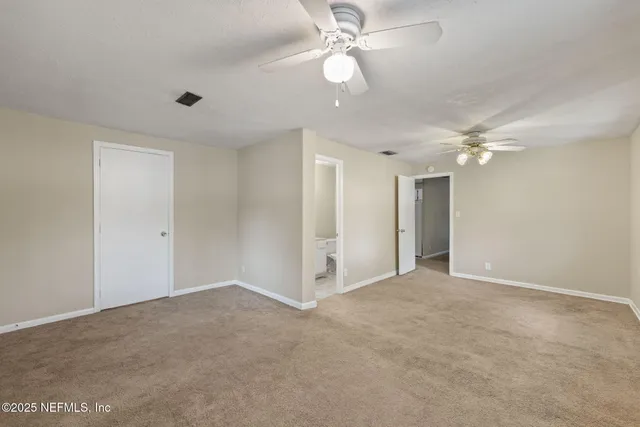 a view of an empty room with a ceiling fan