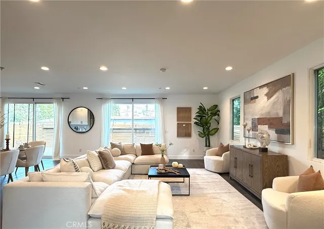 a living room with furniture a large window and a large mirror