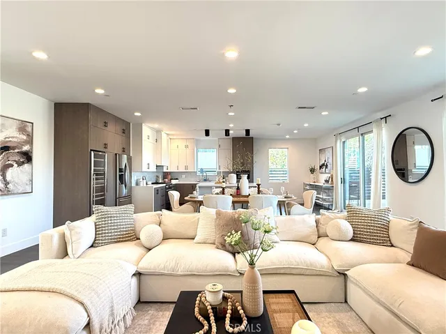 a living room with furniture kitchen and a large window