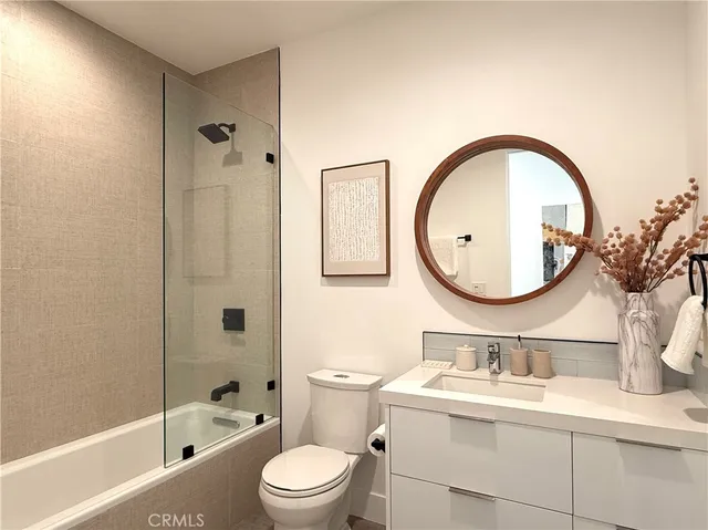 a bathroom with a toilet a sink a mirror and tub