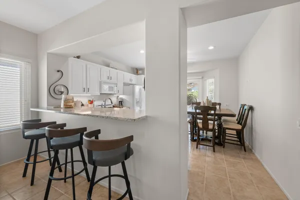 a kitchen with stainless steel appliances granite countertop white cabinets a sink a stove a refrigerator and white cabinets